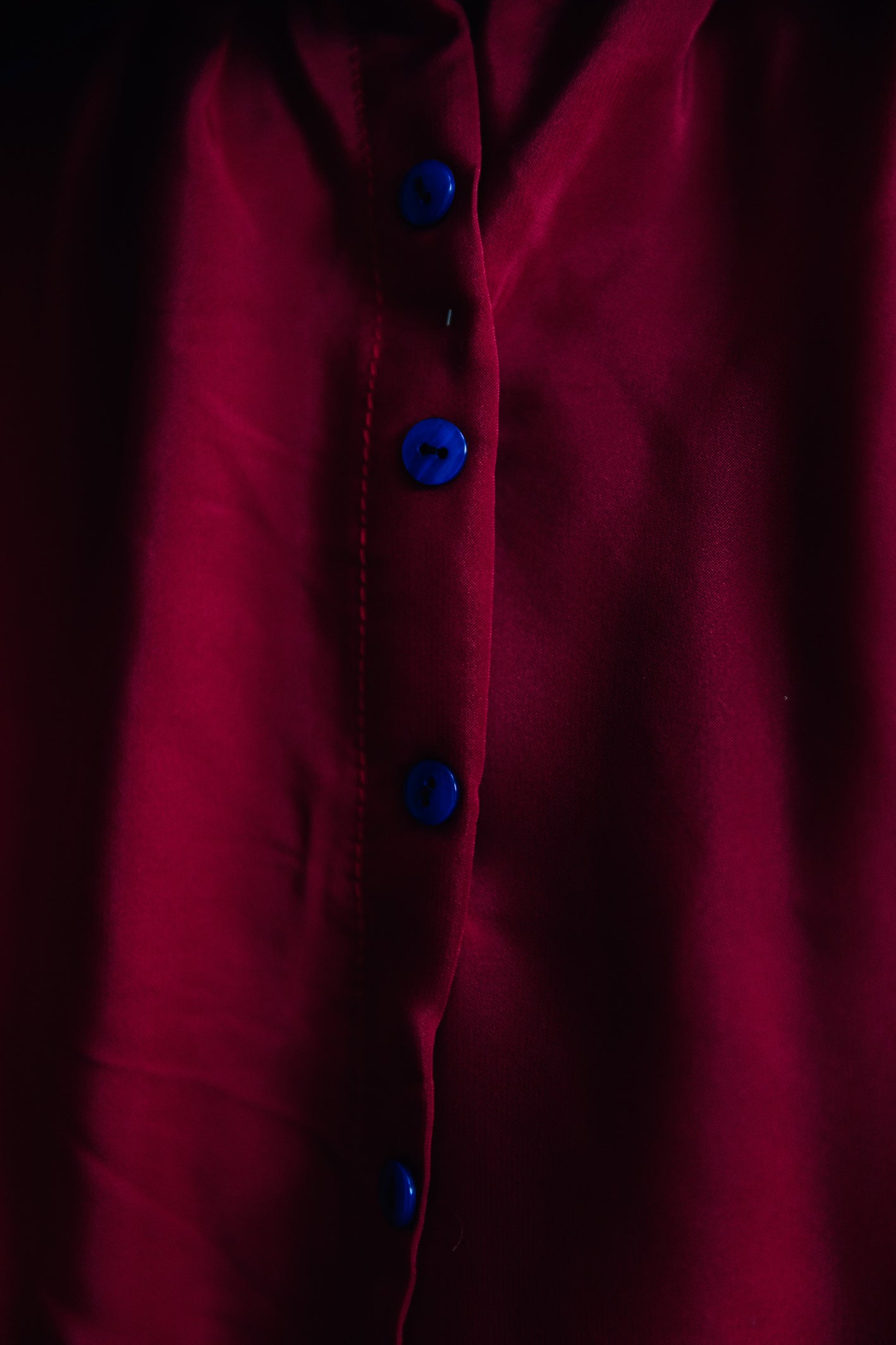 Détail des boutons bleus au dos de la jupe longue 'Adeline' en soie rouge